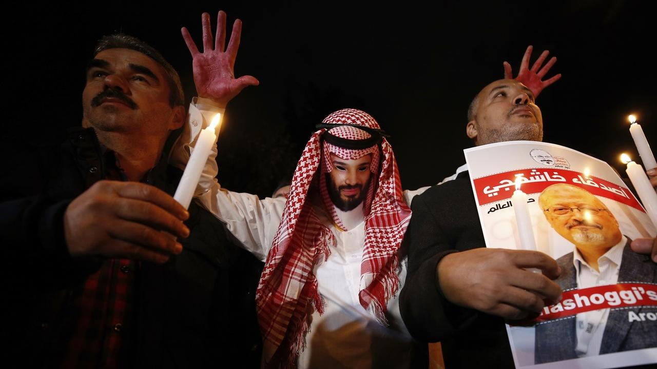 Des manifestants représentent Mohammed ben Salmane les mains pleines de sang, à côté du portrait du journaliste Jamal Khashoggi. Istanbul, le 25 octobre 2018. [Keystone/ap photo - Emrah Gurel]