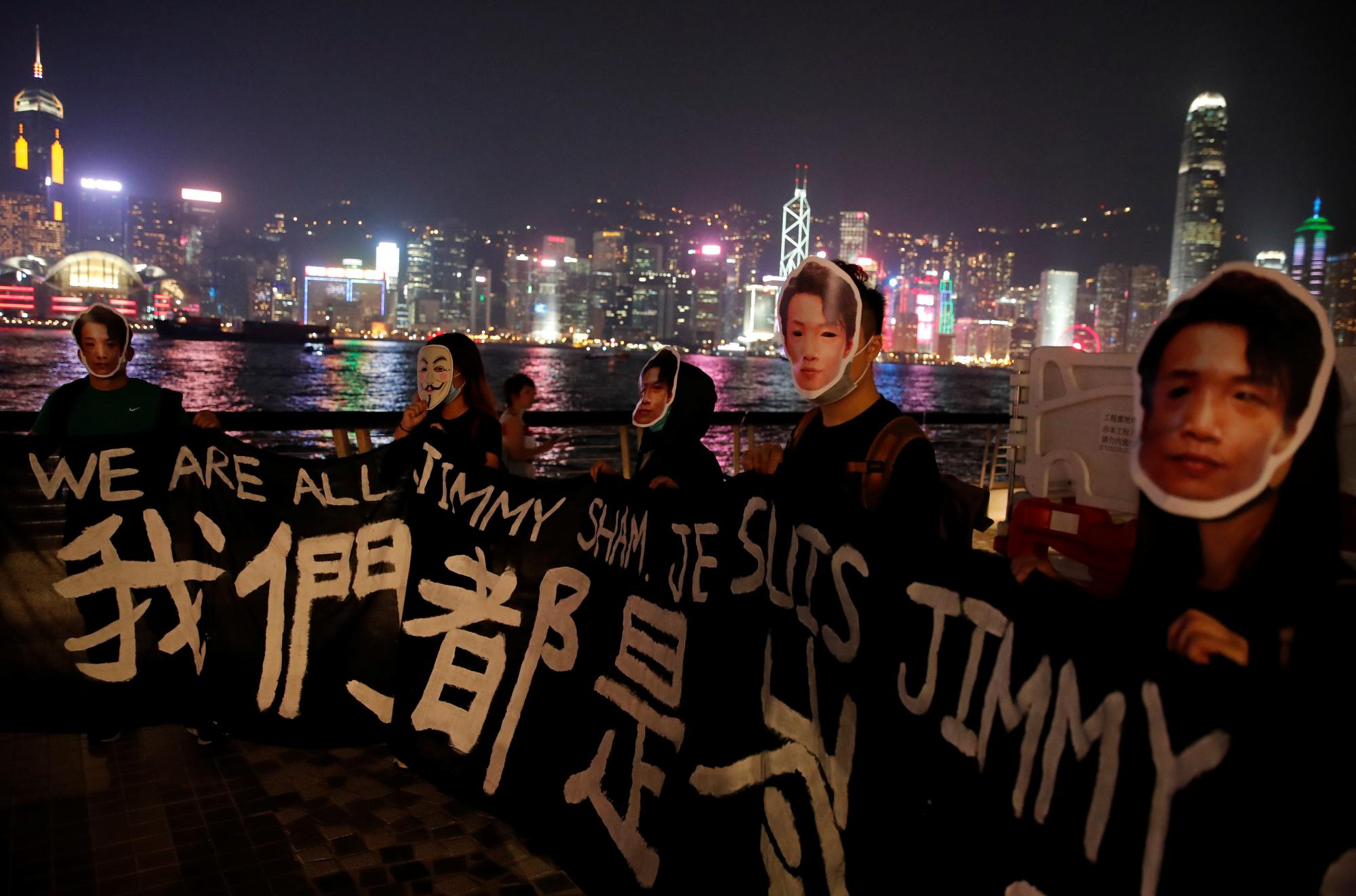 Des manifestants portent un masque représentant le portrait de Jimmy Sham. Leur banderole annonce: "Nous sommes tous Jimmy Sham", Hong Kong, le 18 octobre 2019. [Reuters - Umit Bektas]