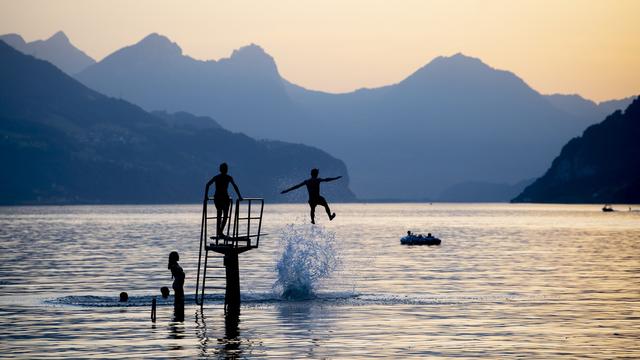 Des jeunes se rafraîchissent en soirée le 25 juin dans le Walensee, près de Walenstadt (SG). [Keystone - Gian Ehrenzeller]