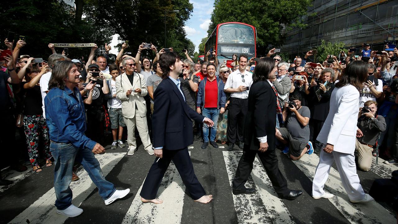 Les fans reproduisent le cliché des Beatles traversant Abbey Road le 08.08.1969. [Reuters - Henry Nicholls]