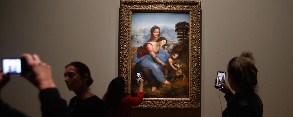 Des visiteurs de l'exposition Leonardo da Vinci" au Louvre à Paris devant la peinture "La Vierge, l'enfant Jésus et Saine Anne". [AFP - François Guillot]