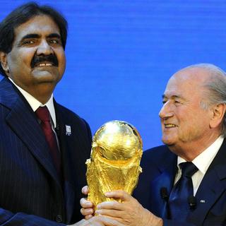 Le 2 décembre 2010 à Zurich, Joseph Blatter (à droite), Président de la FIFA, remet la coupe du monde de football au Cheik Hamad bin Khalifa Al-Thani, Emir du Qatar, après que le pays a été choisi pour organiser la Coupe du monde de football 2022. [KEYSTONE - Walter Bieri]