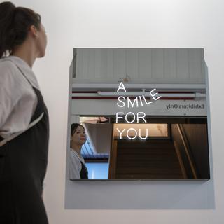 Un femme passe devant une des oeuvres exposées à Art Basel le 12 juin 2019. [Keystone - Georgios Kefalas]