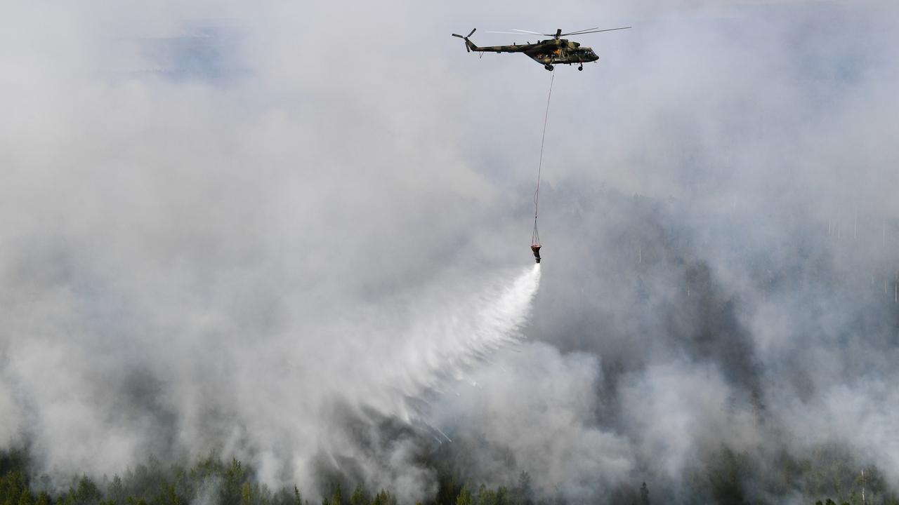 Un hélicoptère des forces russes déverse de l'eau sur les feux de forêt qui se sont déclarés dans le district de Boguchansky, en Sibérie, en août 2019. [Sputnik - Alexandr Kryazhev]