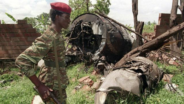 Sur cette photo prise le 23 mai 1994, un rebel du Front patriotique rwandais (FPR) marche à proximité des restes de l'avion du président rwandais Juvenal Habyarimana, abattu le 6 avril 1994 à Kigali (Rwanda). L'attentat contre l'avion présidentiel fut l'élément déclencheur du génocide de 800'000 Tutsi et Hutu modérés, massacrés par la majorité Hutu en 100 jours. Il s'agit du pire génocide de l'histoire récente. [AP/Keystone - Jean-Marc Bouju]