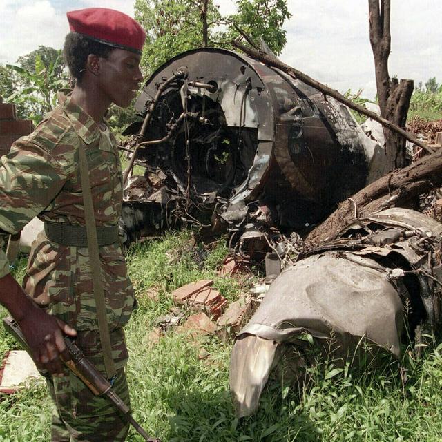 Sur cette photo prise le 23 mai 1994, un rebel du Front patriotique rwandais (FPR) marche à proximité des restes de l'avion du président rwandais Juvenal Habyarimana, abattu le 6 avril 1994 à Kigali (Rwanda). L'attentat contre l'avion présidentiel fut l'élément déclencheur du génocide de 800'000 Tutsi et Hutu modérés, massacrés par la majorité Hutu en 100 jours. Il s'agit du pire génocide de l'histoire récente. [AP/Keystone - Jean-Marc Bouju]