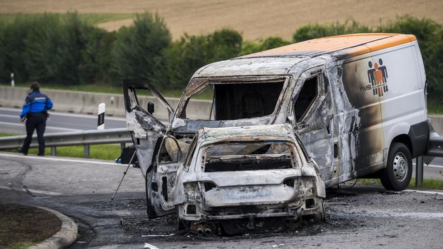 Le fourgon a été incendié alors que les convoyeurs de fonds étaient encore à l'intérieur. [Keystone - Jean-Christophe Bott]