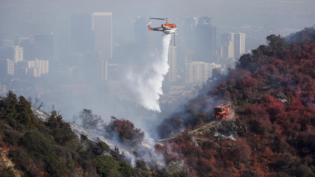 Un hélicoptère largue de l'eau sur le Kenter Canyon, à Los Angeles, ce 28 octobre 2019. [AP Photo - Ringo H.W. Chiu]