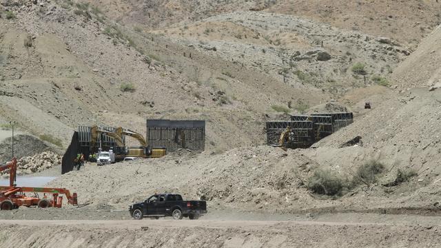 Des ouvriers s'activent pour mettre en place des morceaux de la palissade sur les terres d'un propriétaire à Sunland Park, près de la ville mexicaine de Ciudad Juarez. [Cedar Attanasio]