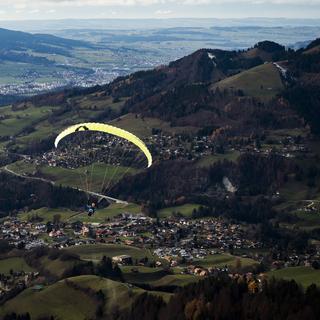 Un parapente décolle du sommet de l'installation RapidoSky des remontées mécaniques de Charmey. [Keystone - Jean-Christophe Bott]