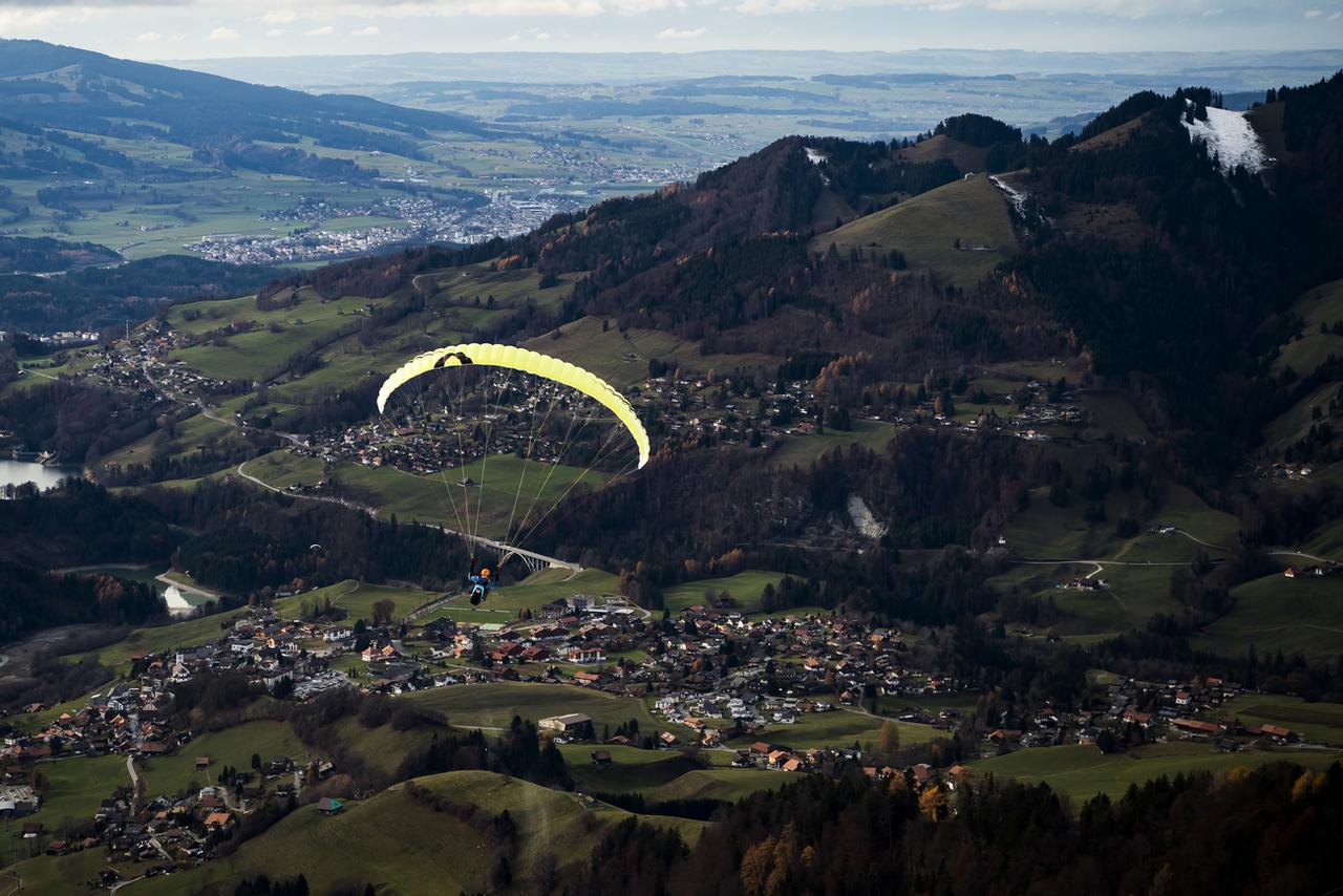 Un parapente décolle du sommet de l'installation RapidoSky des remontées mécaniques de Charmey. [Keystone - Jean-Christophe Bott]