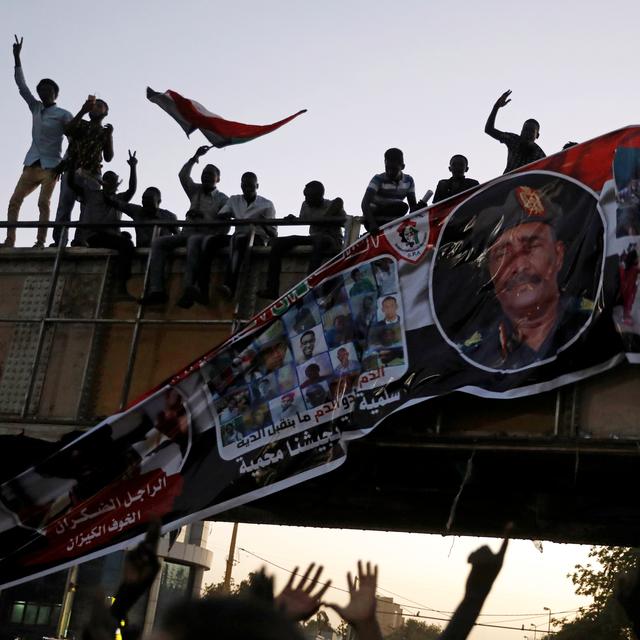 Des manifestants arrachent une bannière représentant le lieutenant général Abdel Fattah Al-Burhan Abdelrahman, la tête du gouvernement de transition au Soudan. [Reuters - Umit Bektas]