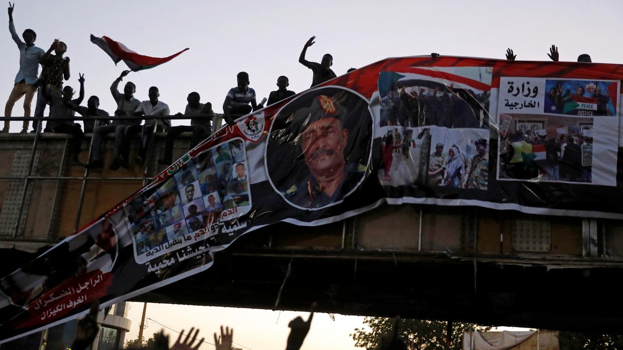 Des manifestants arrachent une bannière représentant le lieutenant général Abdel Fattah Al-Burhan Abdelrahman, la tête du gouvernement de transition au Soudan. [Reuters - Umit Bektas]