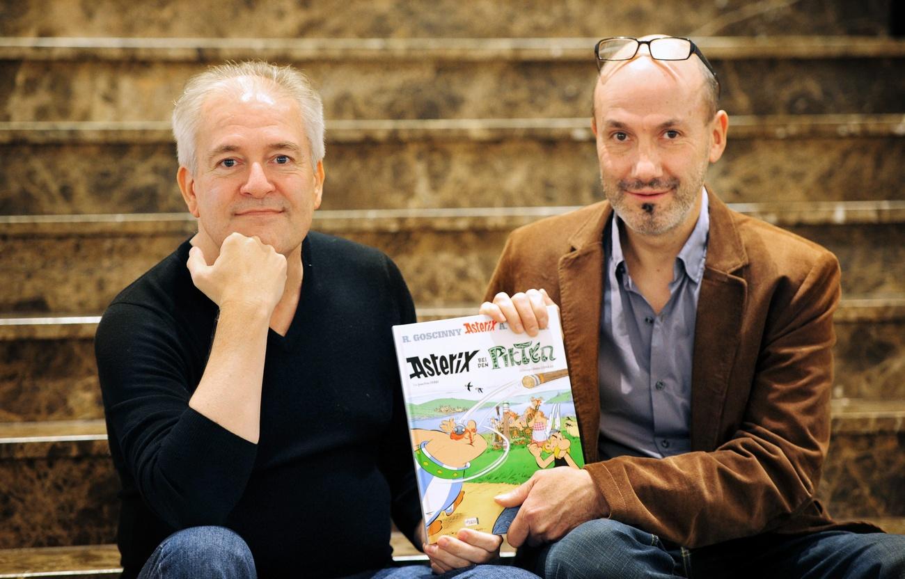 Didier Conrad et Jean-Yves Ferri avec leur premier Astérix en commun. [Keystone - EPA/Daniel Reinhardt]