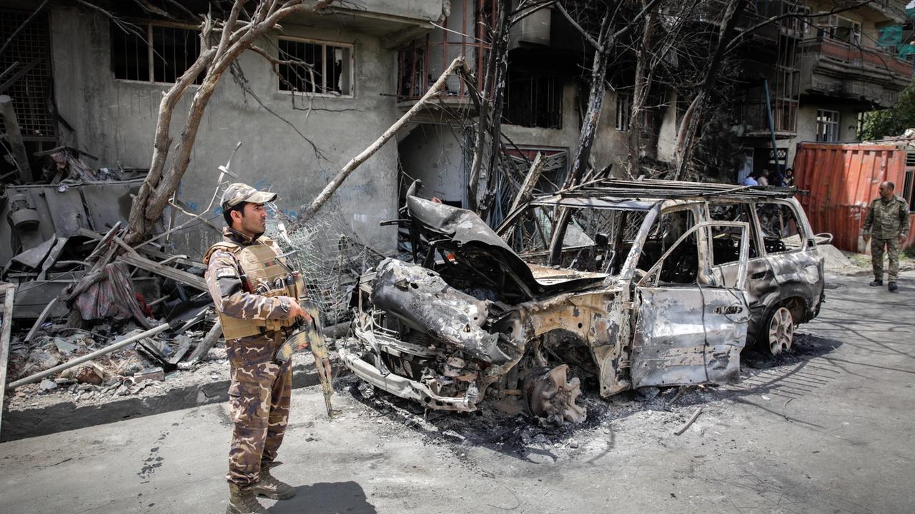 Une voiture calcinée après un attentat à Kaboul ce mardi. [Keystone - EPA/Hedayatullah Amid]