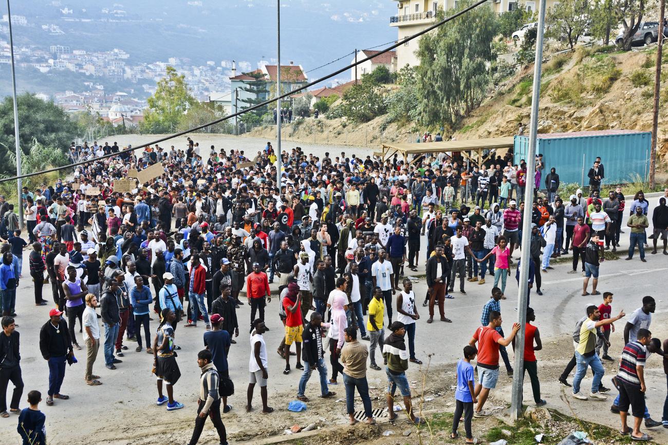 Des réfugiés et des migrants protestent à l'extérieur d'un camp surpeuplé sur l'île grecque de Samos, le 18 octobre 2019. [Keystone/AP Photo - Michael Svarnias]