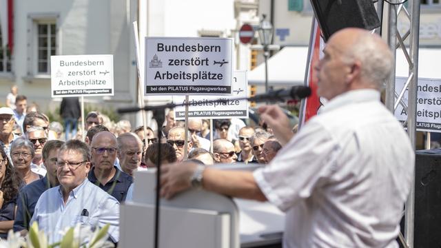 Le conseiller fédéral Ueli Maurer a pris la parole à Stans alors que des employés de Pilatus manifestaient. [Keystone - Urs Flueeler]