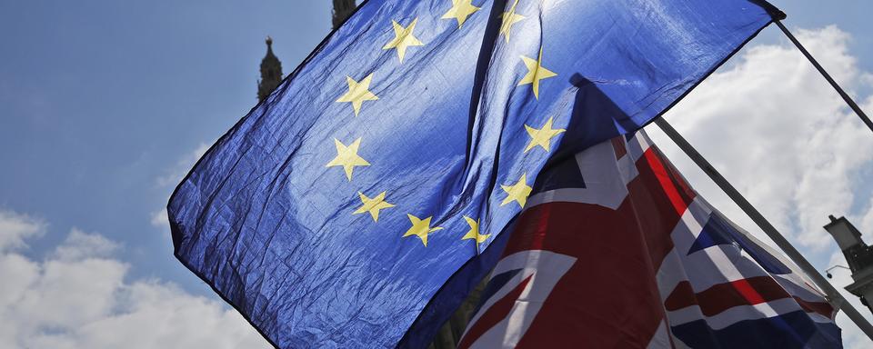 Les drapeaux britannique et européen devant le Parlement à Londres. [AP Photo/Keystone - Frank Augstein]