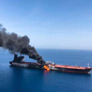 Un pétrolier en feu dans le Golfe d'Oman. [Keystone - EPA/Stringer]