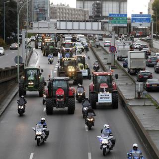 Les agriculteurs en tracteur à Paris manifestent leur colère. [AP Photo/Keystone - Thibault Camus]