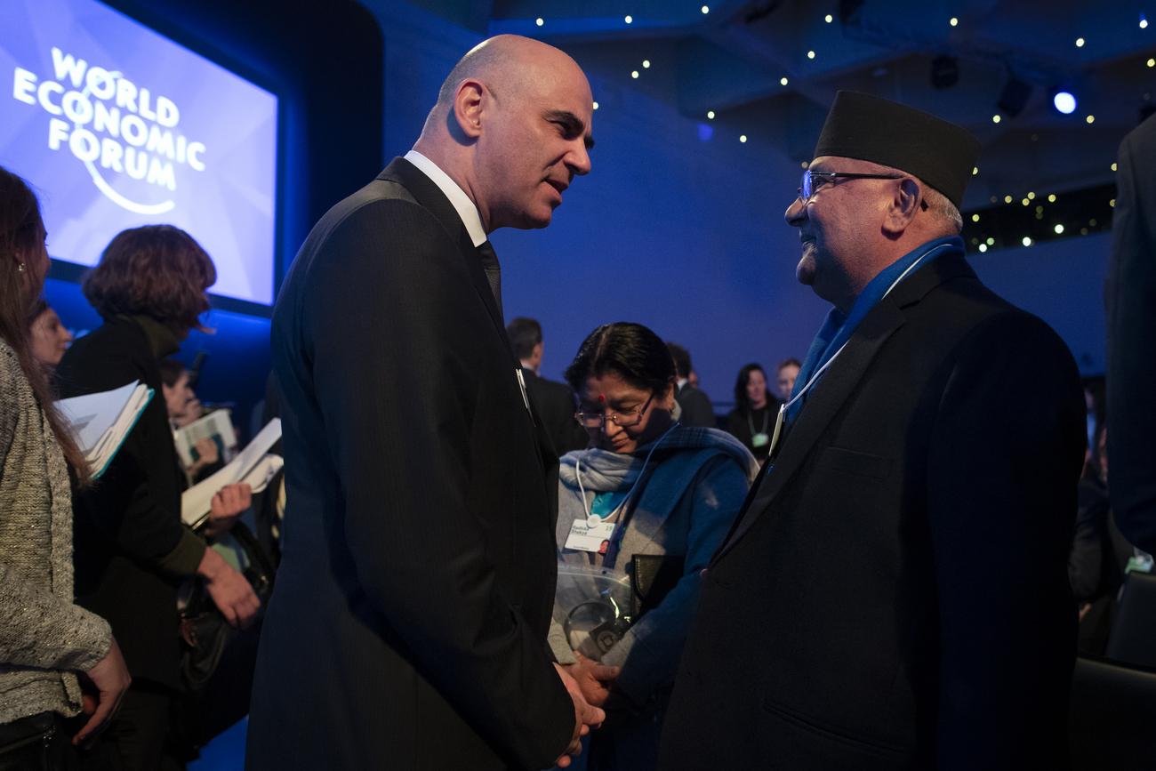 Alain Berset discute avec le Premier ministre népalais Sharma Oli à Davos. [Keystone - Gian Ehrenzeller]