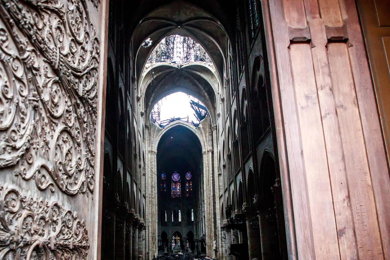 Un trou béant dans le toit de Notre-Dame. [Keystone - EPA/Christophe Petit Tesson]