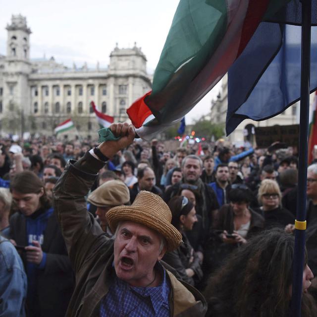 Le 9 avril 2017, devant le Parlement de Budapest, un manifestant crie des slogans pour protester contre un amendement à la loi sur l'université. Cet amendement est considéré par de nombreux Hongrois comme un moyen de fermer l'Université d'Europe centrale, fondée par George Soros. [AP/Keystone - Zoltan Balogh]