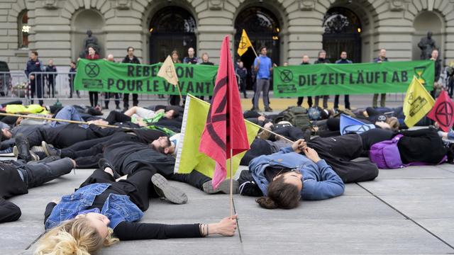 Des militants d'Extinction Rebellion couchés devant le Palais fédéral [Keystone - Anthony Anex]