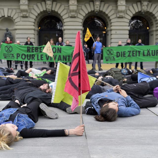 Des militants d'Extinction Rebellion couchés devant le Palais fédéral [Keystone - Anthony Anex]