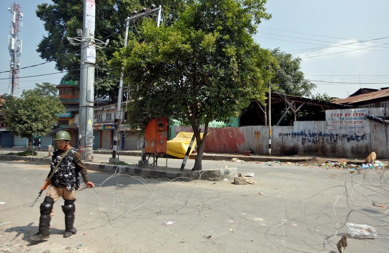 Un policier tire des fils barbelés dans la ville de Srinagar, dans le Cachemire, le 6 août. [Reuters - Danish Ismail]