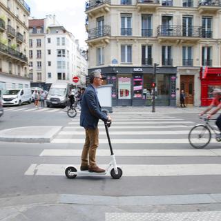 Un homme en trottinette électrique à Paris. [NurPhoto/AFP - Paulo Amorim]