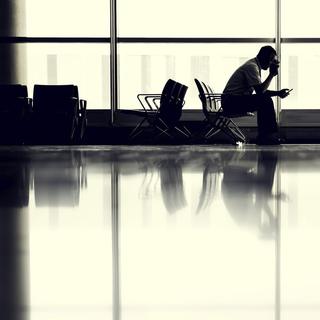 Un homme attend son avion dans un aéroport. [Unsplash - JESHOOTS.COM]