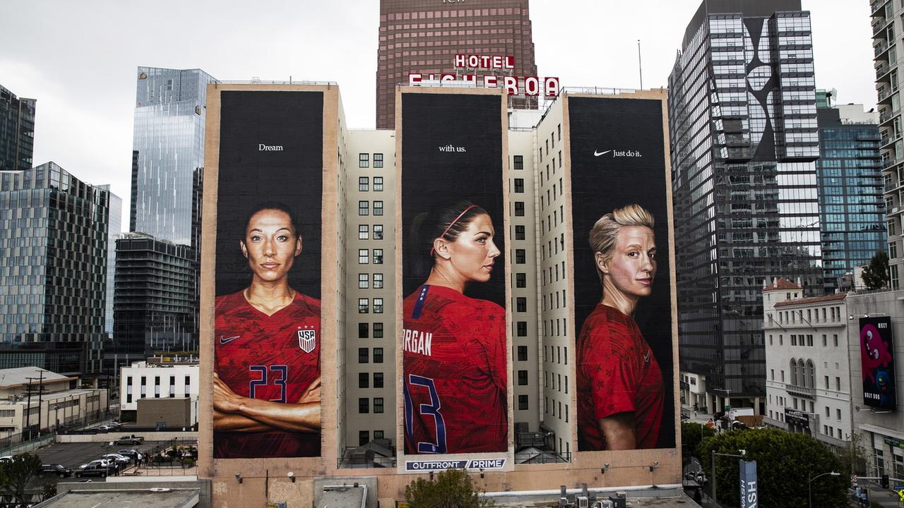 Trois joueuses de l'équipe nationale américaine de football sur d'immenses panneaux publicitaires à Los Angeles (mai 2019). [Keystone/epa - Etienne Laurent]