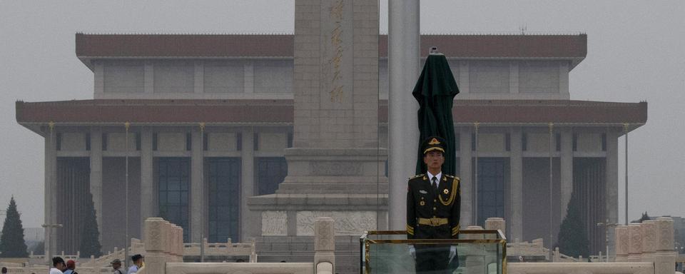 Un garde chinois à proximité du Monument aux Héros du Peuple. [AP Photo/Keystone - Ng Han Guan]