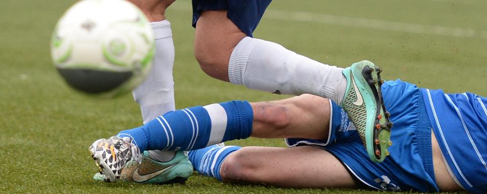 Les faits se sont produits lors d'une rencontre entre deux équipes de football genevoises amateur (photo d'illustration). [DPA/AFP - Daniel Reinhardt]