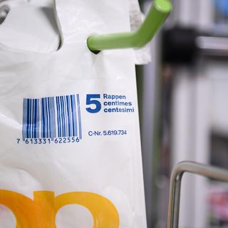 Les sacs plastiques proposés à la caisse de certains magasins de détail sont vendus cinq centimes depuis début 2018. [Keystone - Manuel Lopez]