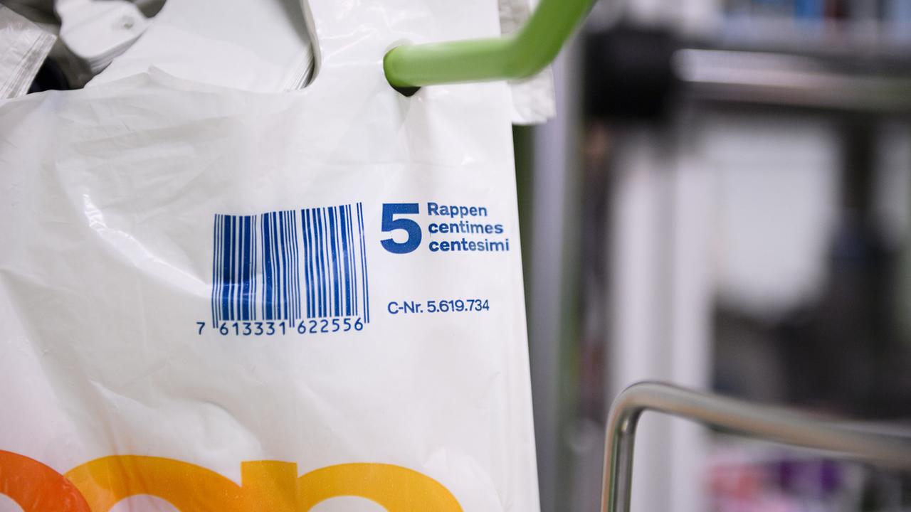 Les sacs plastiques proposés à la caisse de certains magasins de détail sont vendus cinq centimes depuis début 2018. [Keystone - Manuel Lopez]