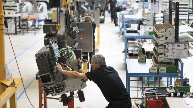 Un employé de la manufacture Tornos assemble une machine sur le site de Moutier (BE). [Keystone - Gaetan Bally]