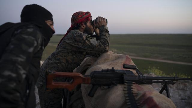 Des combattants des Forces démocratiques syriennes (FDS) positionnés près du réduit de Baghouz le 19 février 2019. [Keystone - AP Photo/Felipe Dana]