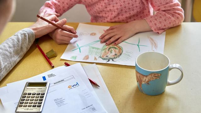 Une mère avec sa fille dessinant sur une table de cuisine (image d'illustration). [Keystone - Christof Schuerpf]