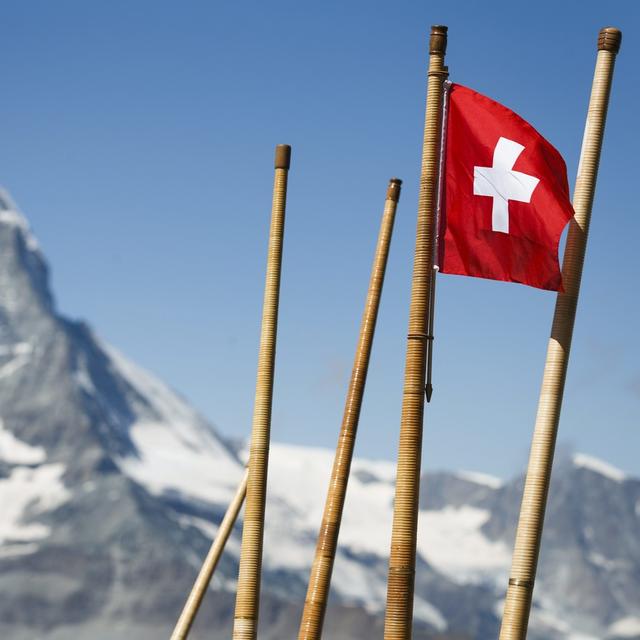 Un drapeau suisse et des cors des Alpes photographiés près de Zermatt. [Keystone - Valentin Flauraud]