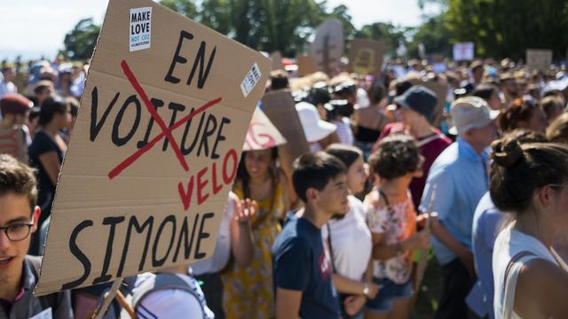 Les militants de la grève pour le climat défilent à Lausanne après le sommet "Smile for Future". [Keystone - Jean-Christophe Bott]