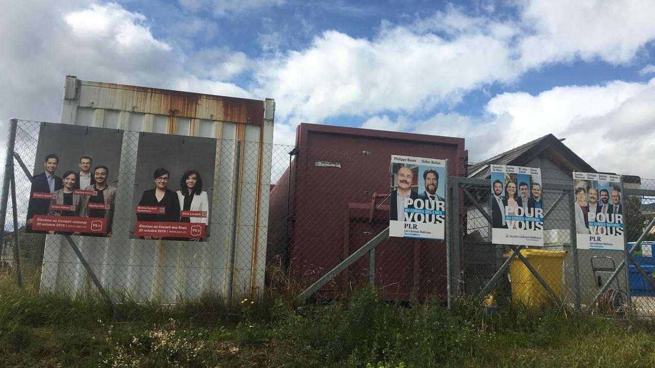 Les affiches de campagne du PS et du PLR à la déchetterie de Corcelles-Cormondrèche (NE). [RTSinfo - Deborah Sohlbank]