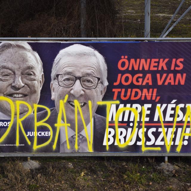 Sur cette photo prise le 26 février 2019 à Budapest, une affiche électorale du gouvernement hongrois représente le Président de la Commission européenne Jean-Claude Juncker et le financier milliardaire américain d'origine hongroise George Soros accompagnés du texte: "Vous avez vous aussi le droit de savoir ce que Bruxelles prépare". L'affiche est sprayée avec les mots: "Orban voleur", en référence au premier ministre hongrois Viktor Orban. [AP / Keystone - Pablo Gorondi]