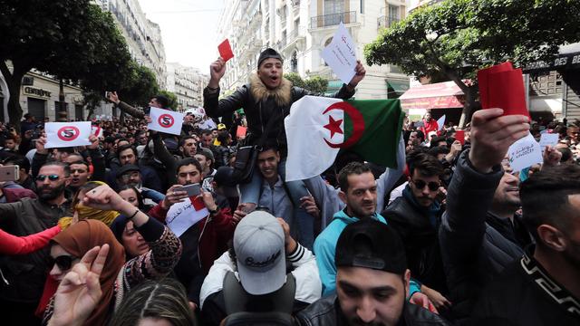 Des dizaines de milliers d'Algériens ont manifesté contre la nouvelle candidature du président Abdelaziz Bouteflika à la tête du pays. [Keystone/EPA - Mohamed Messara]