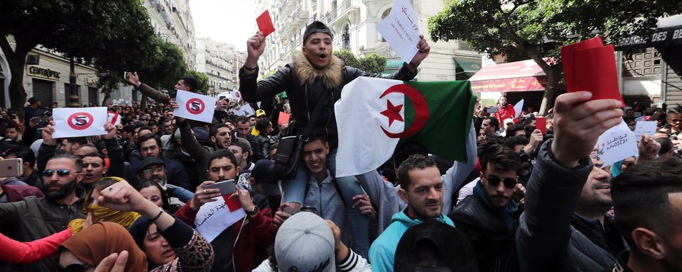 Des dizaines de milliers d'Algériens ont manifesté contre la nouvelle candidature du président Abdelaziz Bouteflika à la tête du pays. [Keystone/EPA - Mohamed Messara]