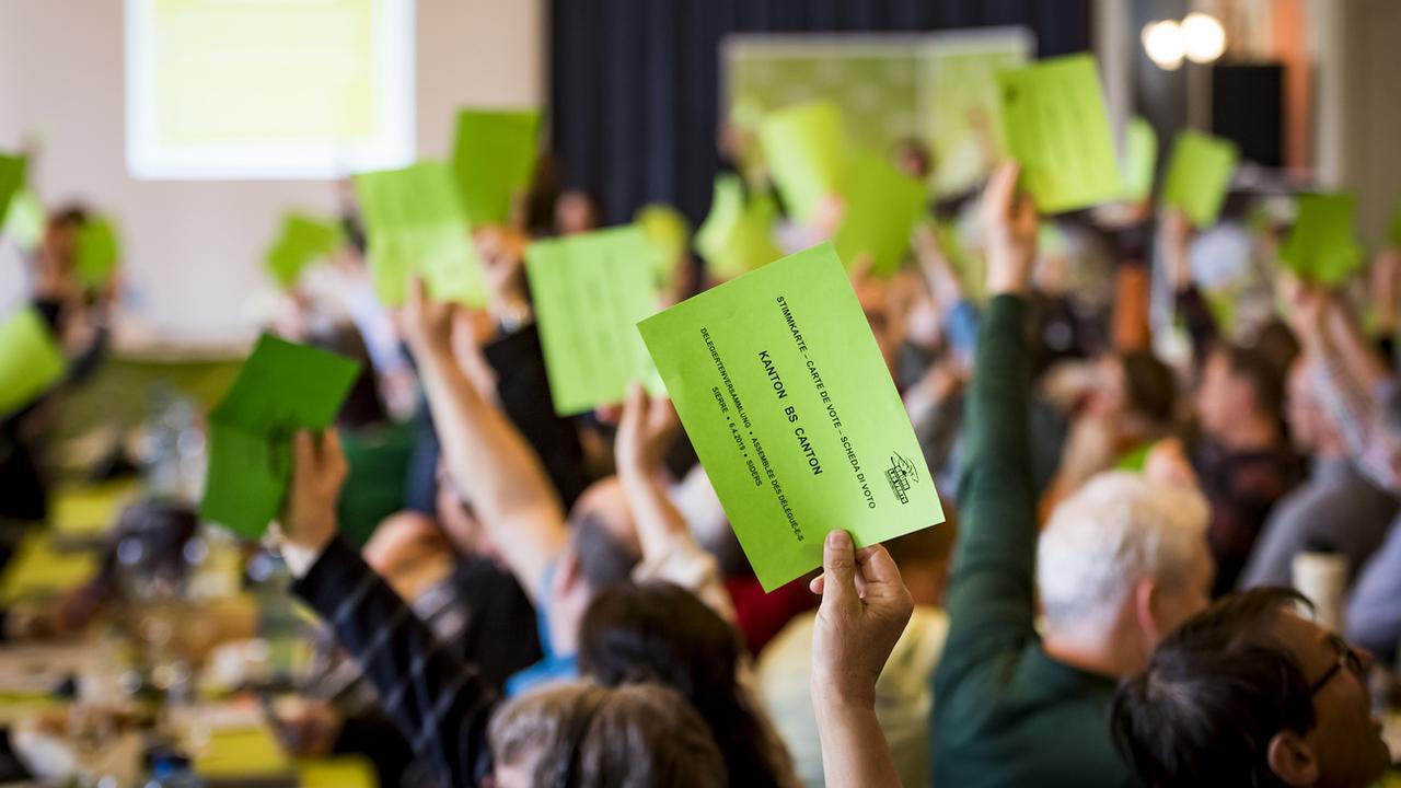 Des délégué-é-s vert-e-s- qui votent lors d'une assemblée. (Image d'illustration). [Keystone - Jean-Christophe Bott]