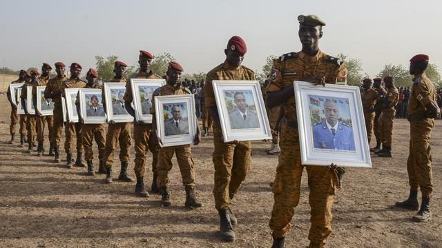 Le 20 décembre 2016 à Ouagadougou, des militaires burkinabè défilent avec les portraits de soldats tués lors d'une attaque du groupe islamique Ansaroul Islam à Nassoumbou. [AFP - Ahmed Ouoba]