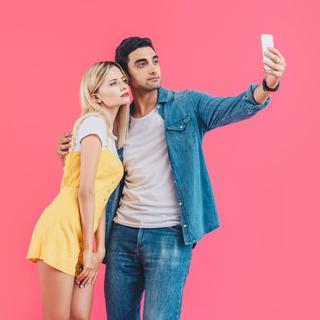 Deux personnes prennent une selfie avec leur Smartphone. [Depositphoto - VitalikRadko]