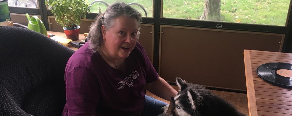 Josiane Stoll, créatrice de l'entreprise de pompes funèbres pour animaux domestiques "Amis Forever", pose avec ses deux chiens huskies Cayenne et Spyke. [RTS - Fabrice Gaudiano]